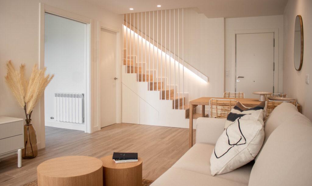 Modernes Apartmentinterieur mit Holztreppe und offenem Raum, Wohn- und Esszimmer zusammen.