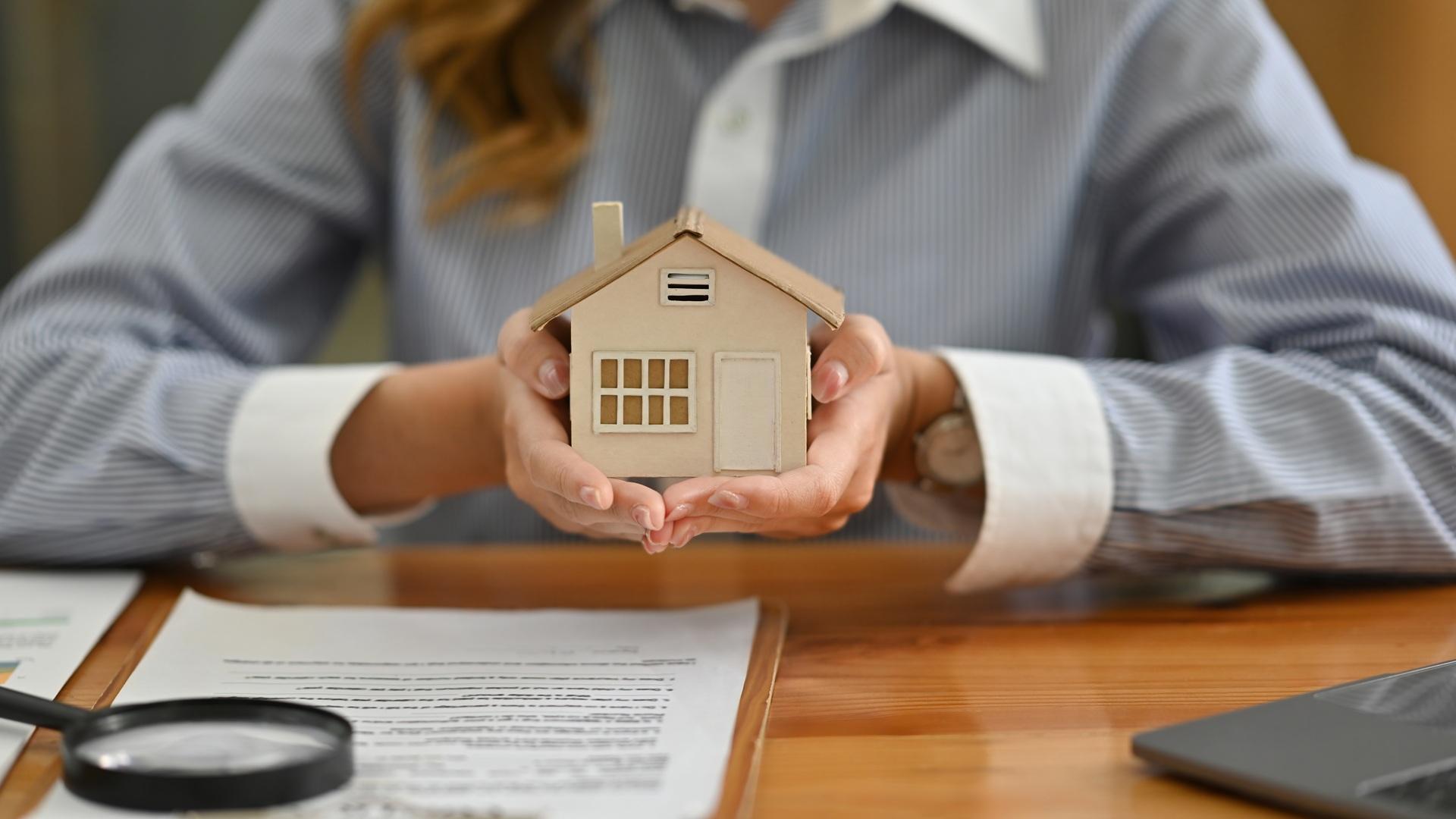 Modellhaus in Händen über Vertragsdokumenten | Entkalkungsanlage

