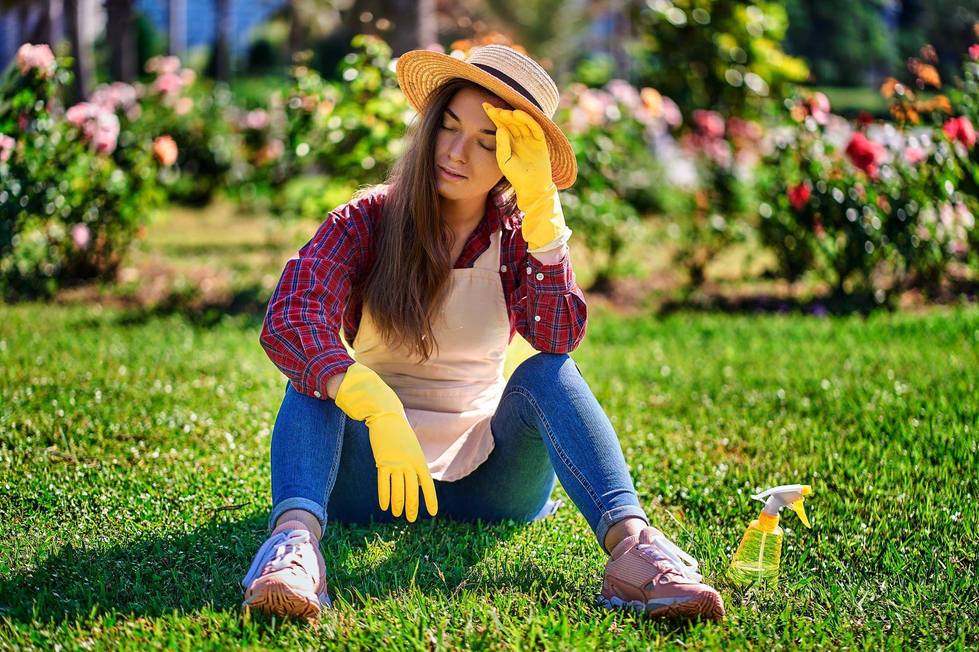 Frau im Garten erschöpft bei Sonne